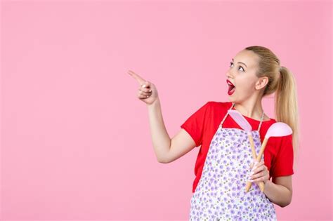 Free Photo Front View Young Housewife Posing With Cutlery On Pink Wall