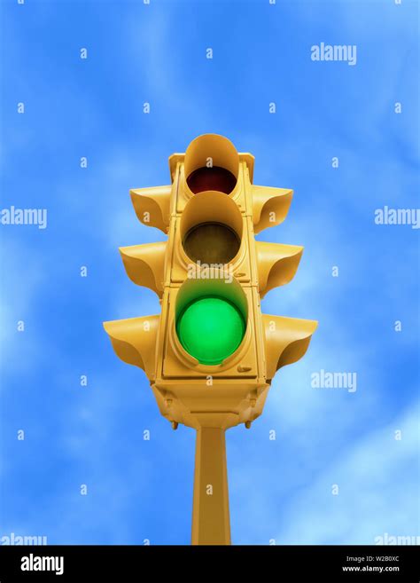 Upward View Of Tall Vintage Yellow Traffic Signal With Green Light On