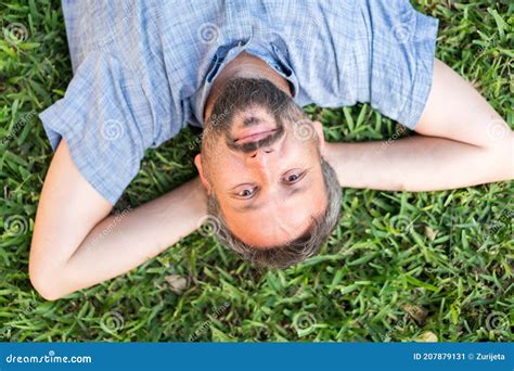 Adult Caucasian Man Lying Upside Down Portrait On Grass Meadow Stock