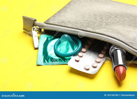 cosmetic bag with contraceptives and red lipstick on background closeup safe sex concept stock