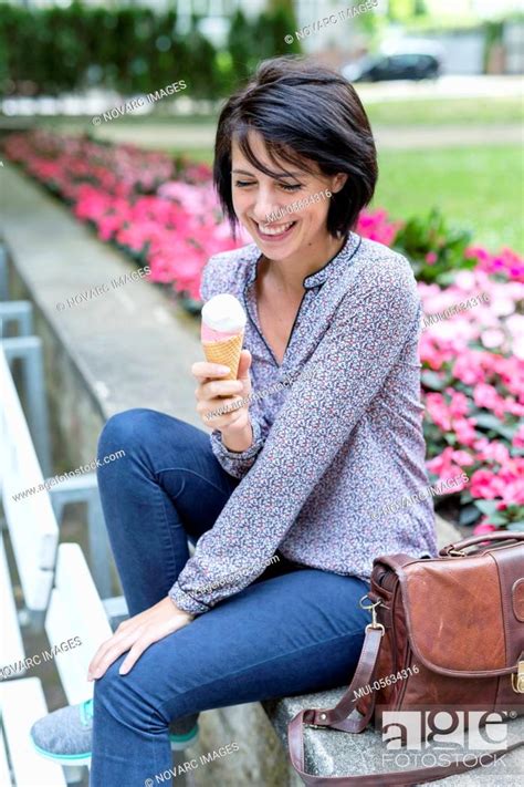 Laughing Woman Sits On Bench And Eats Ice Cream Stock Photo Picture And Royalty Free Image