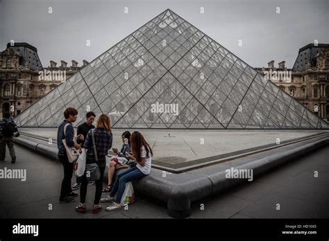 Tourists In The Louvres Central Courtyards With The Louvre Pyramid And