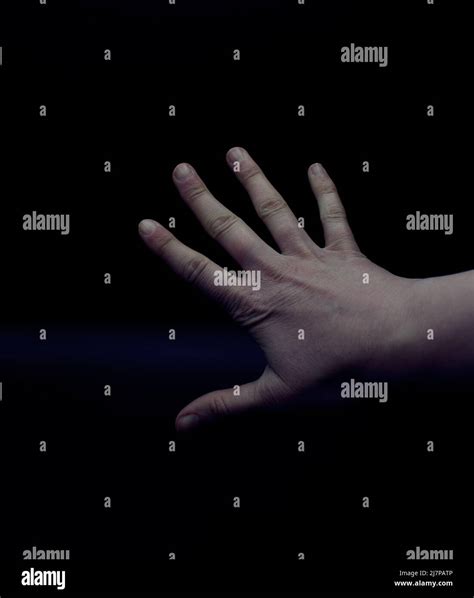 Hand With Spread Fingers Against A Black Backdrop Stock Photo Alamy