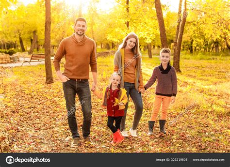 Familia Feliz Caminando En El Parque De Otoño Fotografía De Stock