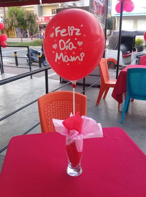 A Red Balloon With The Words Feliz Do Mesna On It Sitting In A Vase