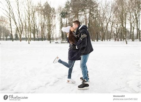 Couple Ice Skating On A Frozen Lake Kissing And Embracing A Royalty