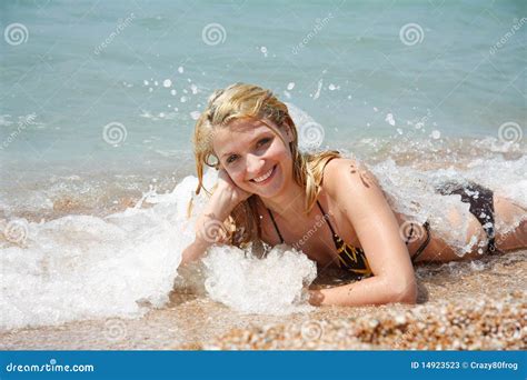 Gelukkig Meisje Dat Op Strand In Waterdalingen Legt Stock Afbeelding