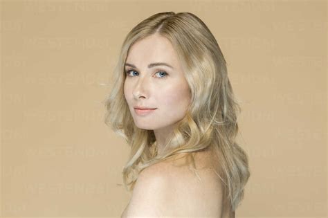 Portrait Of Naked Blond Woman In Front Of Beige Background Stock Photo
