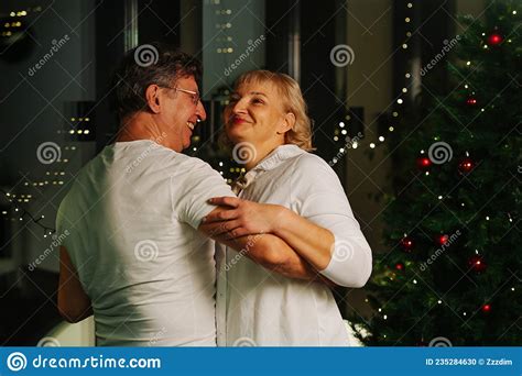 Genuinely Happy Sixty Year Old Couple Dancing Next To A Christmas Tree