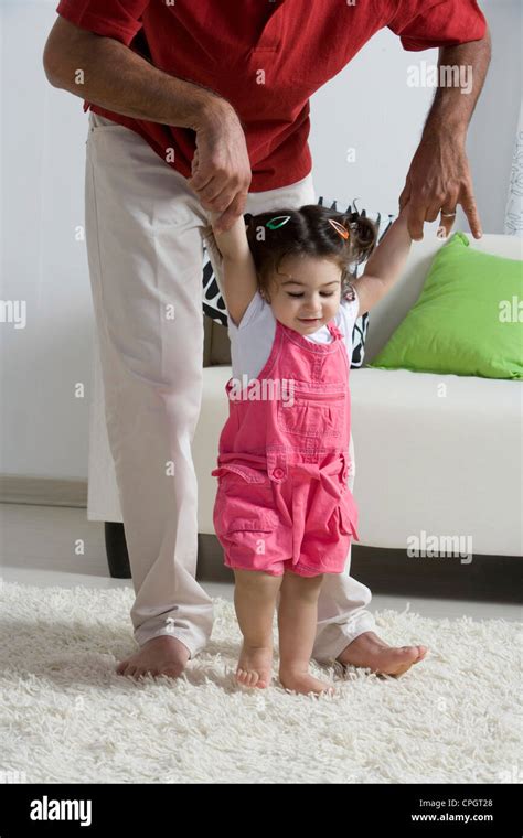 Padre Enseñando A Su Hija A Caminar En Casa Fotografía De Stock Alamy