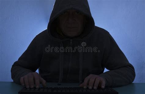 Hacker Wearing Hoodie Using Dask Keyboard To Crack Computer Blue