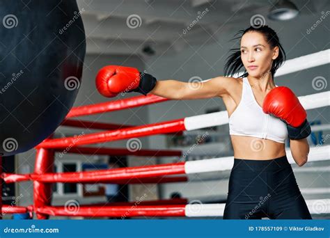 Female Boxer Hitting A Huge Punching Bag At Fitness Gym Stock Image