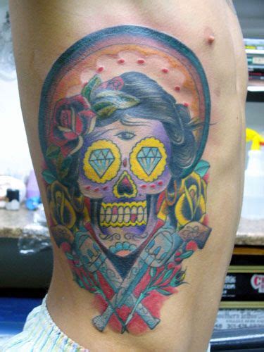 There is a gun to the left side of the skull and a few roses on its right side. Menu | Guns and roses, Sugar skull, Rose tattoos