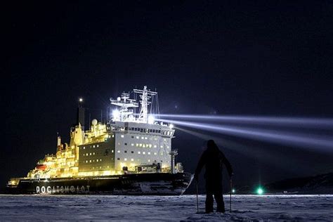 A Giant Icebreaker Ship Lights Up The Night Sky As It Arrives In