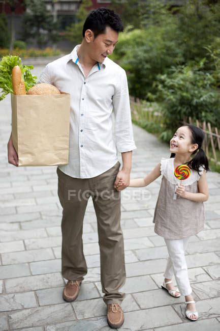 Chinese Father And Daughter Walking On Street With Groceries — Elementary Age Male Stock