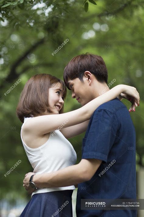 Young Chinese Couple Embracing In Park — Bonding Young Couple Stock