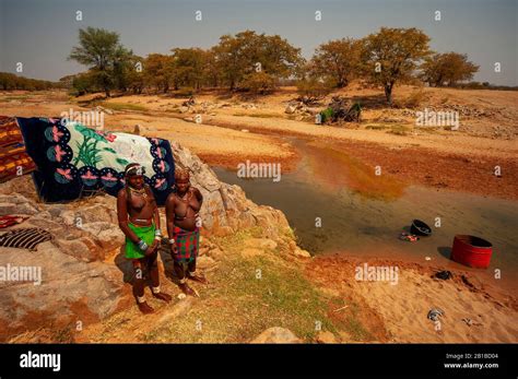 African Womans Washing Clothes On A Small Stream Right By The Road