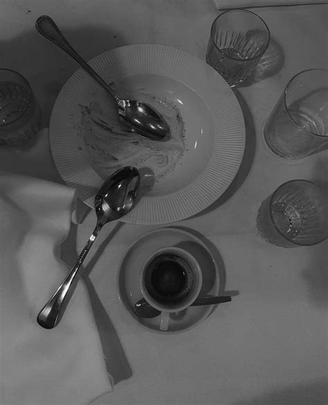 A Table Topped With Plates And Cups Filled With Liquid Next To Utensils