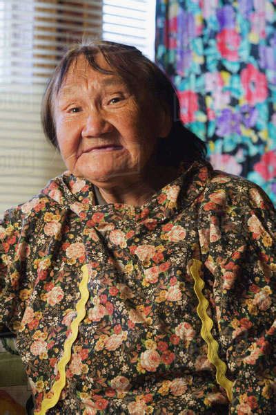 Portrait Of Elder Yupik Native Woman Sitting At Her Kitchen Table