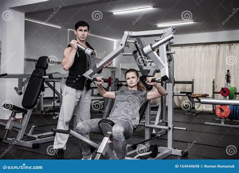 Personal Coach Instructing Young Woman In Gym Stock Photo Image Of