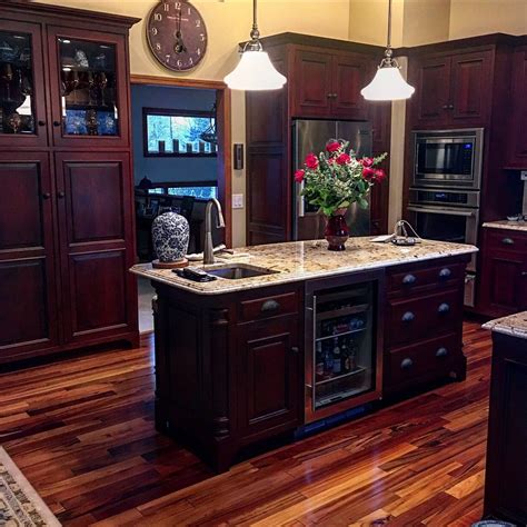 Natural woods make the highest quality kitchen cabinets by far. Dark cabinets with light countertops. Kitchen island, tiger wood floors, beautiful kitchen, ki ...