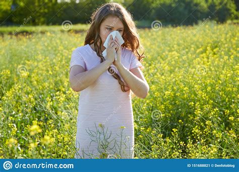 Seasonal Allergy To Pollen The Girl Sneezes And Closes Her Nose With A Napkin Stock Image