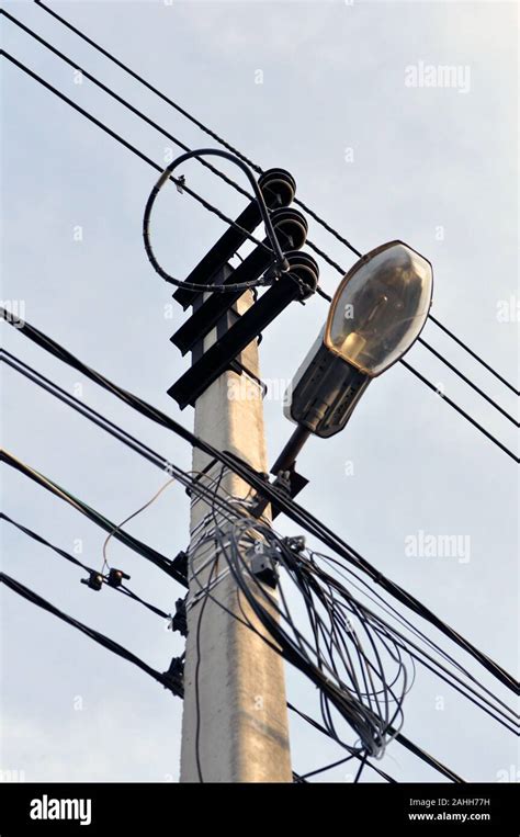 Street Lighting Pole With Lamp And Wires Against The Sky Stock Photo