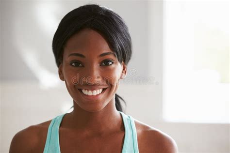 Head And Shoulders Portrait Of Smiling Young Black Woman Stock Photo
