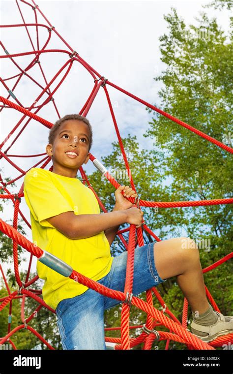 Looking Boy Holds And Climbs On Red Ropes Stock Photo Alamy