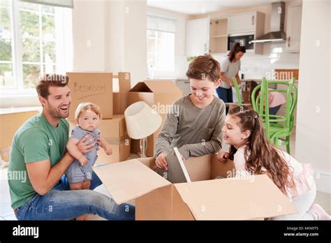 Children Helping Parents To Unpack On Moving In Day Stock Photo Alamy