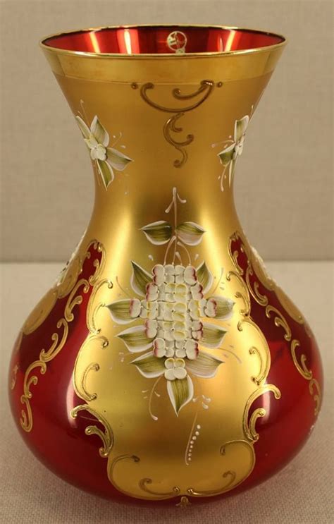 A Red And Gold Vase Sitting On Top Of A Table