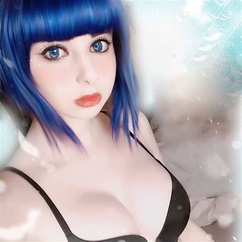 A Woman With Blue Hair And Black Bra Posing For A Photo In Front Of Snowflakes