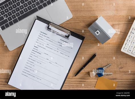 Top View Of Clipboard With Property Management Agreement House Model