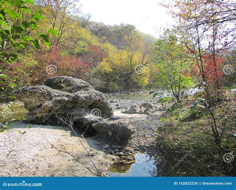 Stunning Autumn Landscape With A Large Stone On The River River Among