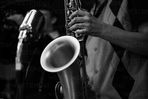 Midsection Of Man Playing Saxophone During Concert Stock Photo