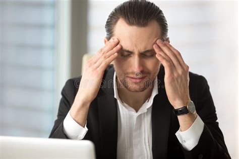 Exhausted Businessman Having A Headache After Long Work Hours Stock