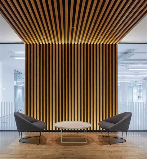 An Office Lobby With Two Chairs And A Coffee Table In Front Of A Wooden