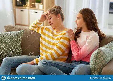 Teenage Girl Comforting Her Sad Friend At Home Stock Photo