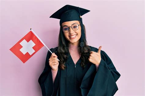 Young Hispanic Woman Wearing Graduation Uniform Holding Switzerland