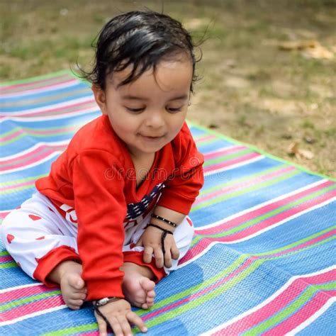 Cute Little Indian Infant Sitting Enjoying Outdoor Shoot At Society