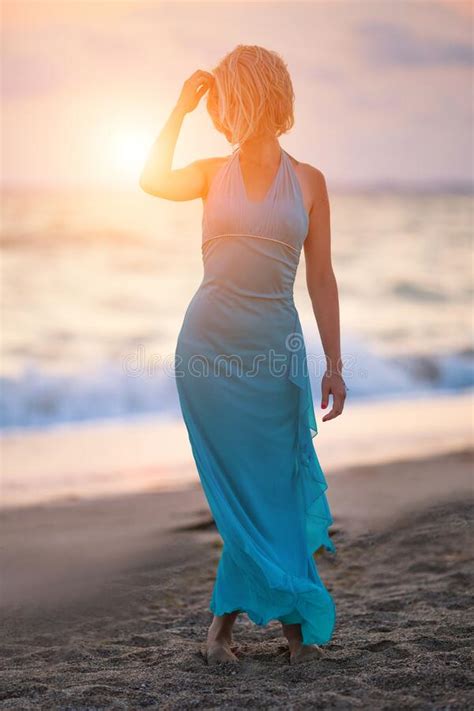 Beautiful Young Woman In Elegant Dress On The Beach At