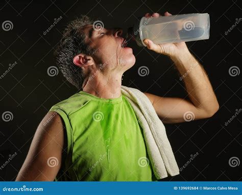 Young Sweaty Attractive And Fit Sport Man Drinking Water Holding Bottle