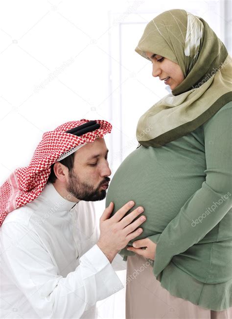 Pregnant Muslim Wife Smiling With Her Husband Kissing Bellyand His