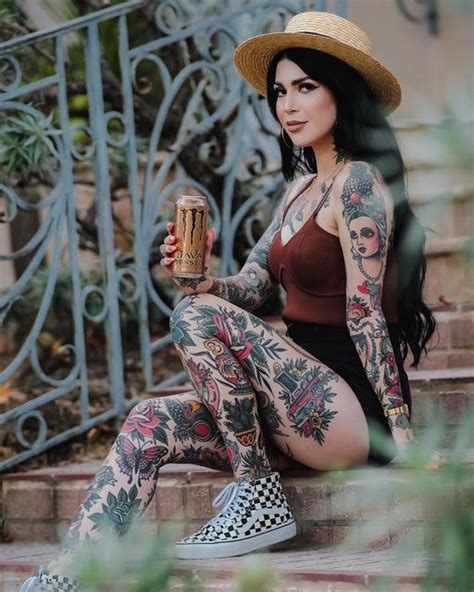 A Woman With Tattoos Sitting On Steps Holding A Beer