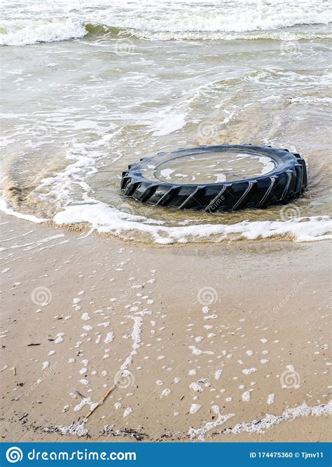Marine Pollution By Industrial Waste Tractor Tire In Sea Water Stock