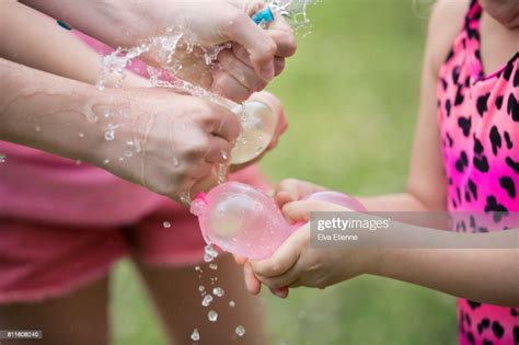 Children Squeezing And Bursting Water Balloons High Res Stock Photo