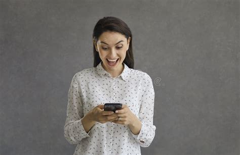 Joyful Woman Holding A Phone In Her Hands Reads Positive Comments In