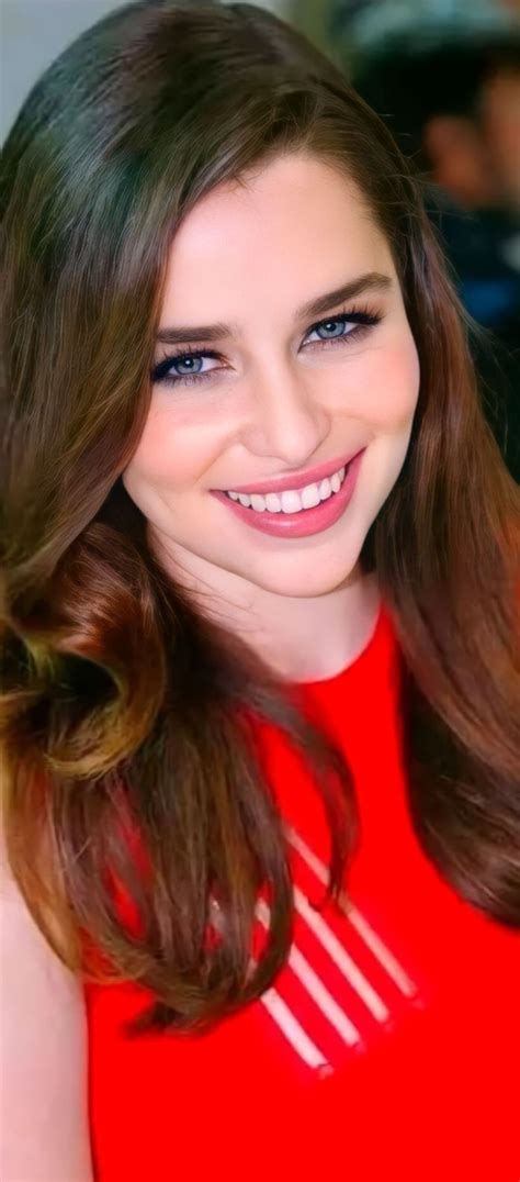 A Woman With Long Brown Hair Wearing A Red Dress And Smiling At The Camera
