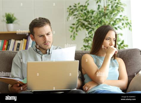 Husband Addicted To Work And Unsatisfied Wife Beside Him Looking Away