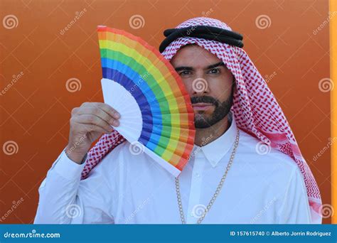 Attractive Arabic Gay Man Holding A Fan With The Rainbow Flag Stock